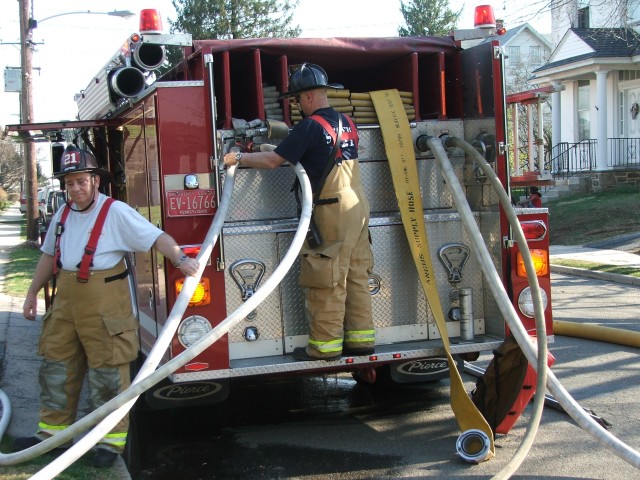 Past Chief Chuck Deaver and Dave Vining operating Engine 4 at a building fire at Market and Sixth Streets.