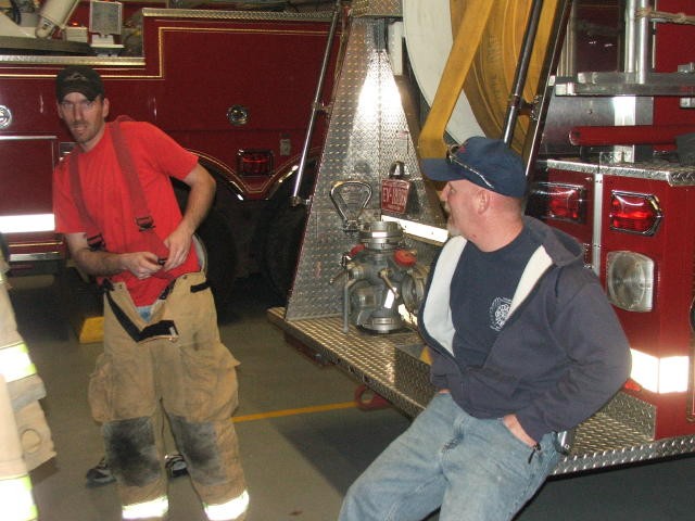 Firefighters Morgan Derr and Tim Kelly, Sr. chatting at the back of Engine 2.