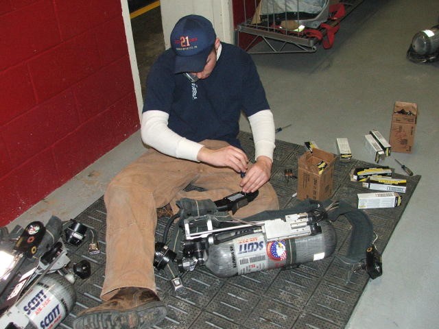 Firefighter Brian Slauch replacing batteries in an SCBA.