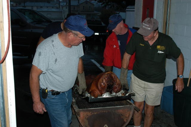 Past Chief Rich Terry, Past President Frank Moroney, and Tim Kelly, Sr. pulling the pig off of the cooker.