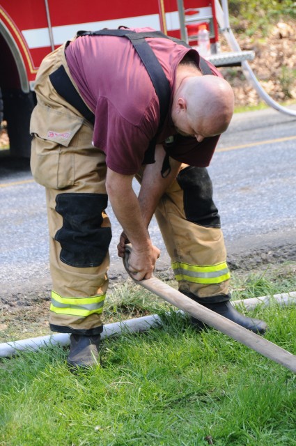 Firefighter Mark Vining rolling hose.