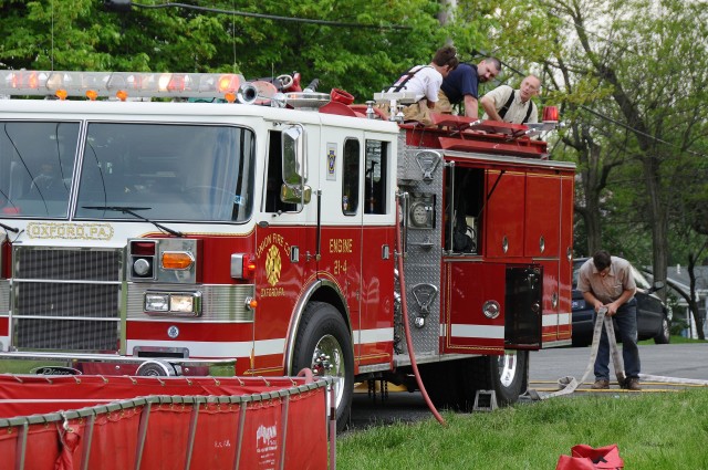 Firefighters Andy McCullin, Robert Bishop, and Brian Brown on top of Engine 21-4 racking lines after the Nottingham Park fire.