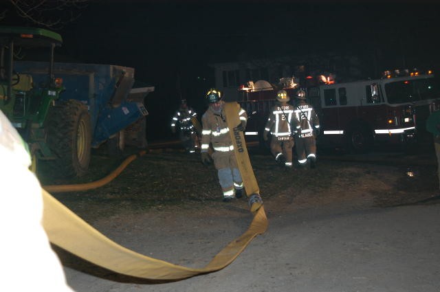 Firefighter Brian Neubauer dragging a supply line at a Rising Sun barn fire.