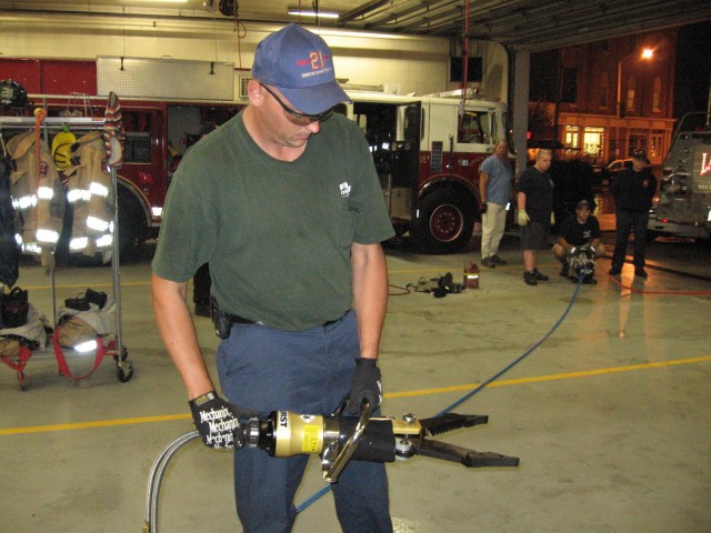 Firefighter Dennis Byrd operates a Hurst cutter during drill.