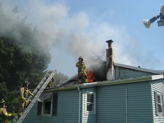 Safety Officer Brian Brown operates on the roof of house fire on Mount Pleasant Avenue.