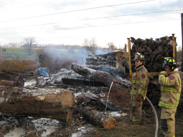 Firefighters Matt Woolston and Jay McKinney at a wood pile fire on Whiteside Drive.