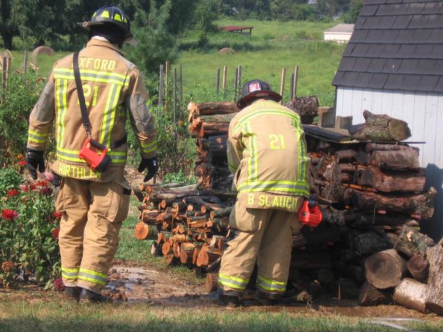 Firefighter Bill Hirthler and Hoseman Brian Slauch at a wood pile fire on Media Road.