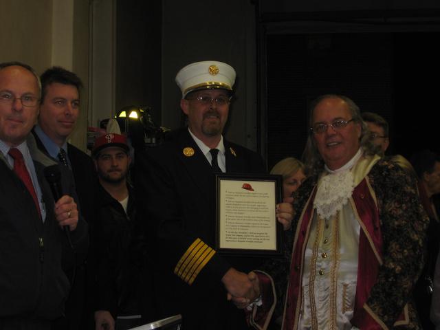 Fire Chief Mark Vining shaking hands with Ben Franklin.