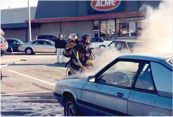 Gaining access to an engine compartment at car fire in the Acme parking lot.