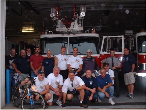 The members posing with members of the FDNY during a stop on their 9/11 memorial bike ride.