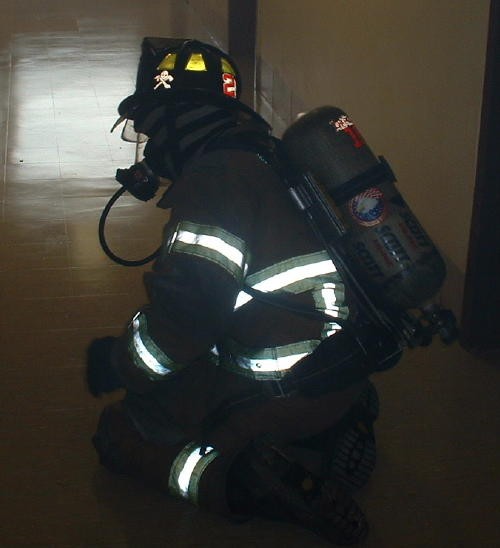 Firefighter Randy Gray crawling down a hallway at Lincoln University.