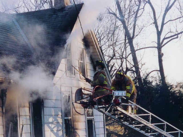 The Truck crew opening windows on the Bravo side at house fire on Spring Valley Road.